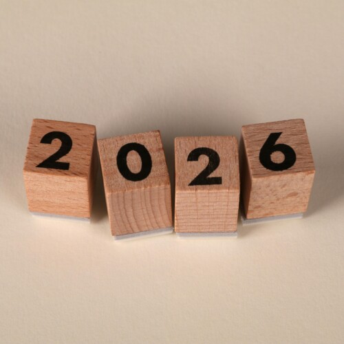 Wooden cubes forming the year 2026 on a neutral background.